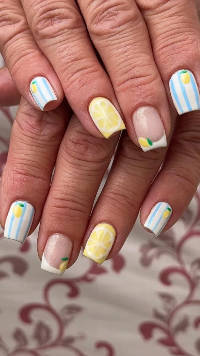 Nail art citrons jaunes sur fond blanc rayé bleu
